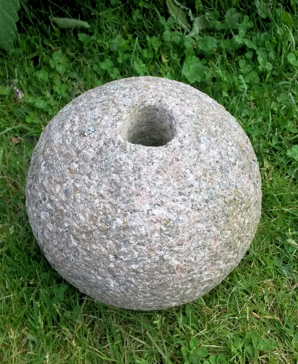 Kivipallo reikä keskellä.