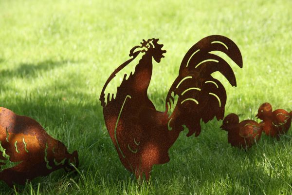 Ruosteiset kana kukko ja tipu puutarhakoristeet nurmikolla